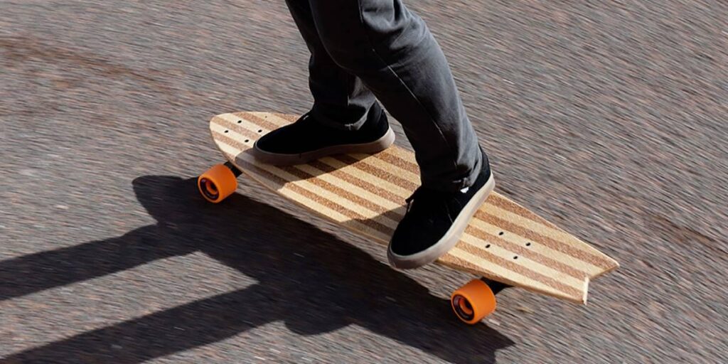 close up of person's feet riding a bamboo longboard