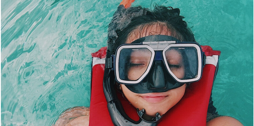 Beginner snorkelling diver wearing double-lens diving mask