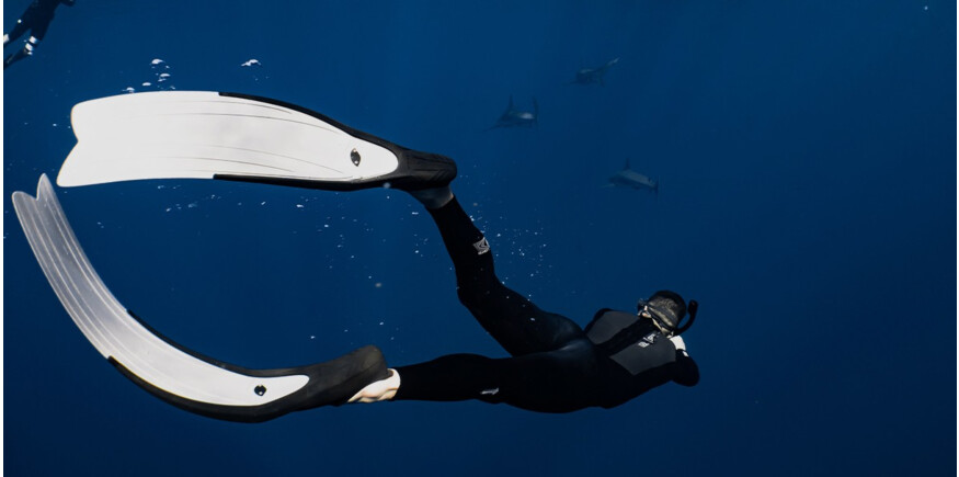Diver wearing long flippers swimming underwater