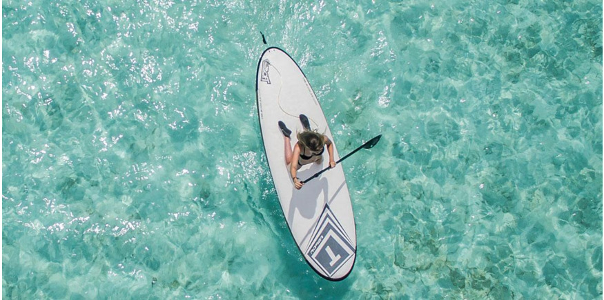 Woman paddle boarding in tropical waters