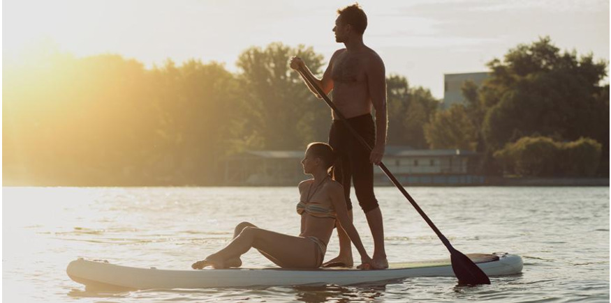 Paddling couple on stand-up paddle board with SUP paddle