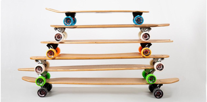 a stack of different sized bamboo longboards and skateboards