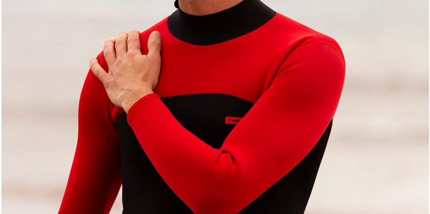 close up of man standing in wetsuit on the beach