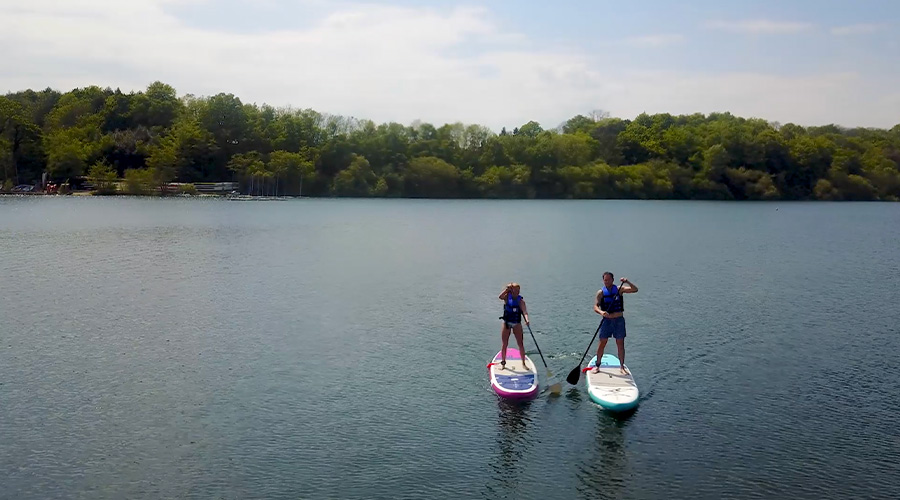 riders paddle on still water on inflatable paddleboards