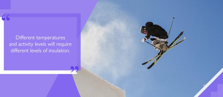 Skier wearing ski jacket performing ski jump on slope