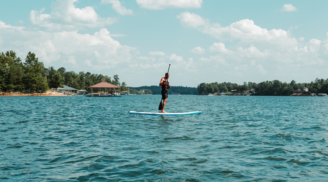 paddleboarder on the water in tropical location